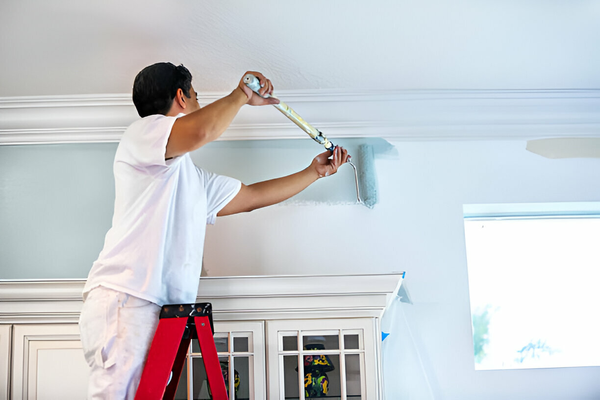 Painter applying paint to an interior wall